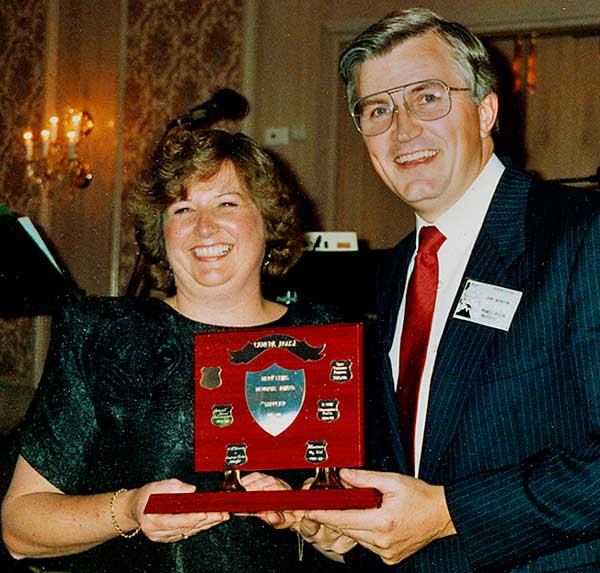 Sue Lewis presents John Swainston, as MD of Maxwell Optical, the Merv Lewis Memorial Supplier of the Year Award at the Camera House AGM, approx. 1994.